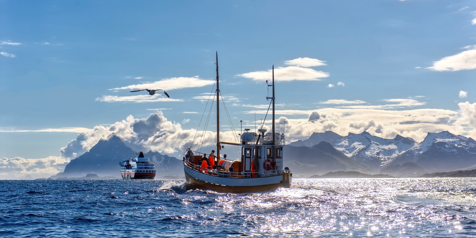 Ett fartyg från Hurtigruten går mot horisonten med en lokal fiskebåt bakom sig 