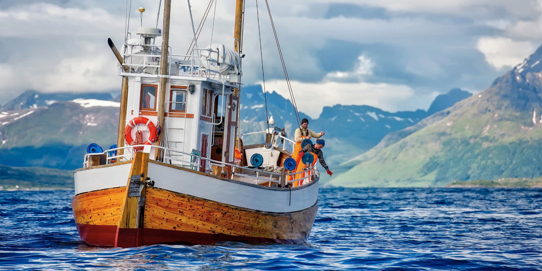En fiskebåt med två fiskare i Nordnorge