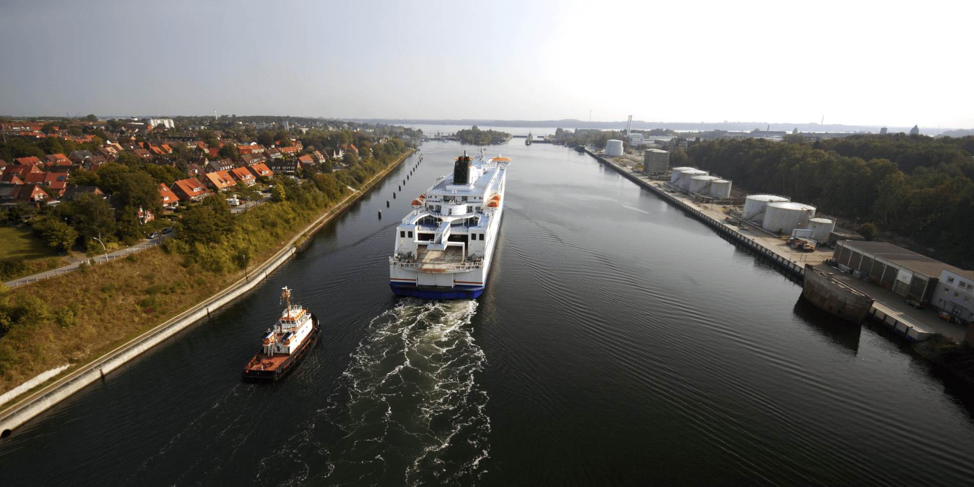 Bogserbåt och kryssningsfartyg i Kielkanalen.