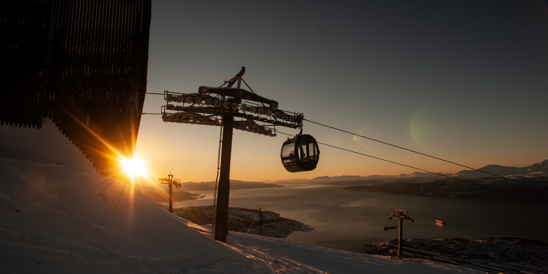 Cable Car going up Narvikfjellet at sunset. Its snow, but the light is warm
