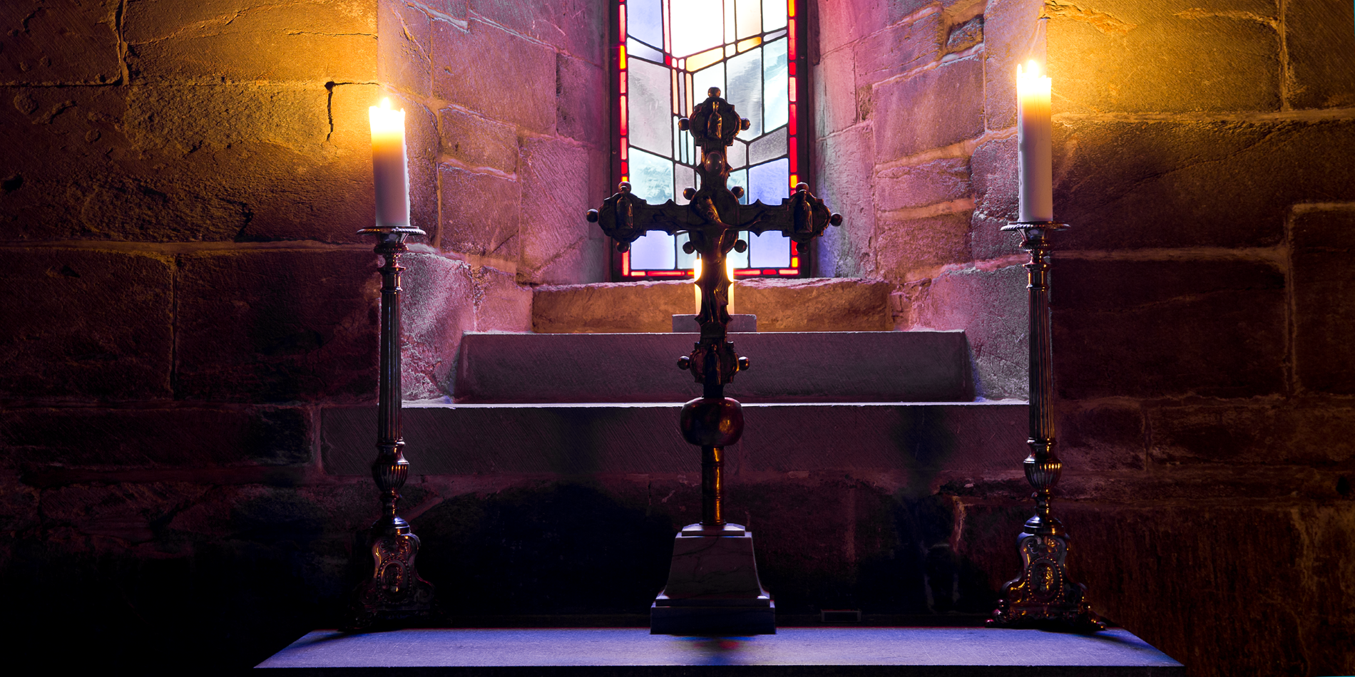 Nidarosdomens dolda rum. Bilden visar ett kors och två tända ljus inuti Nidarosdomen