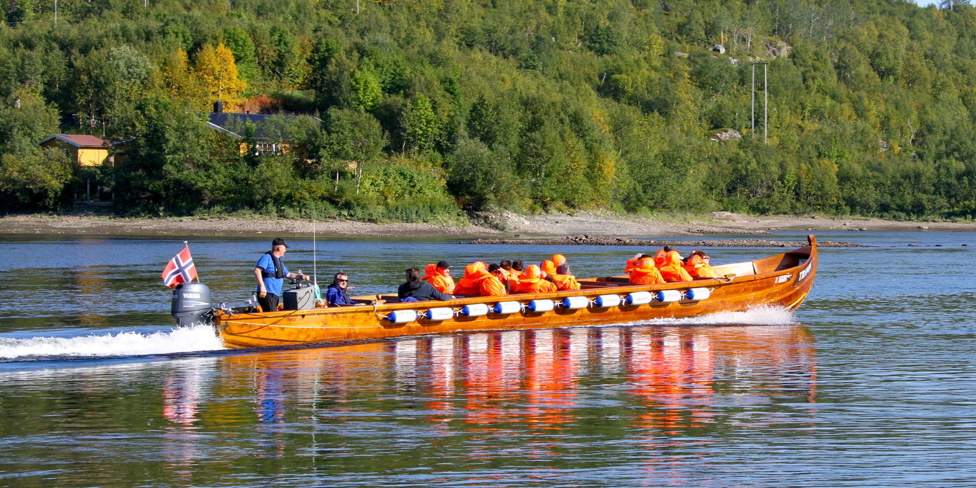 En grupp människor som rider på ryggen av en båt i vattnet
