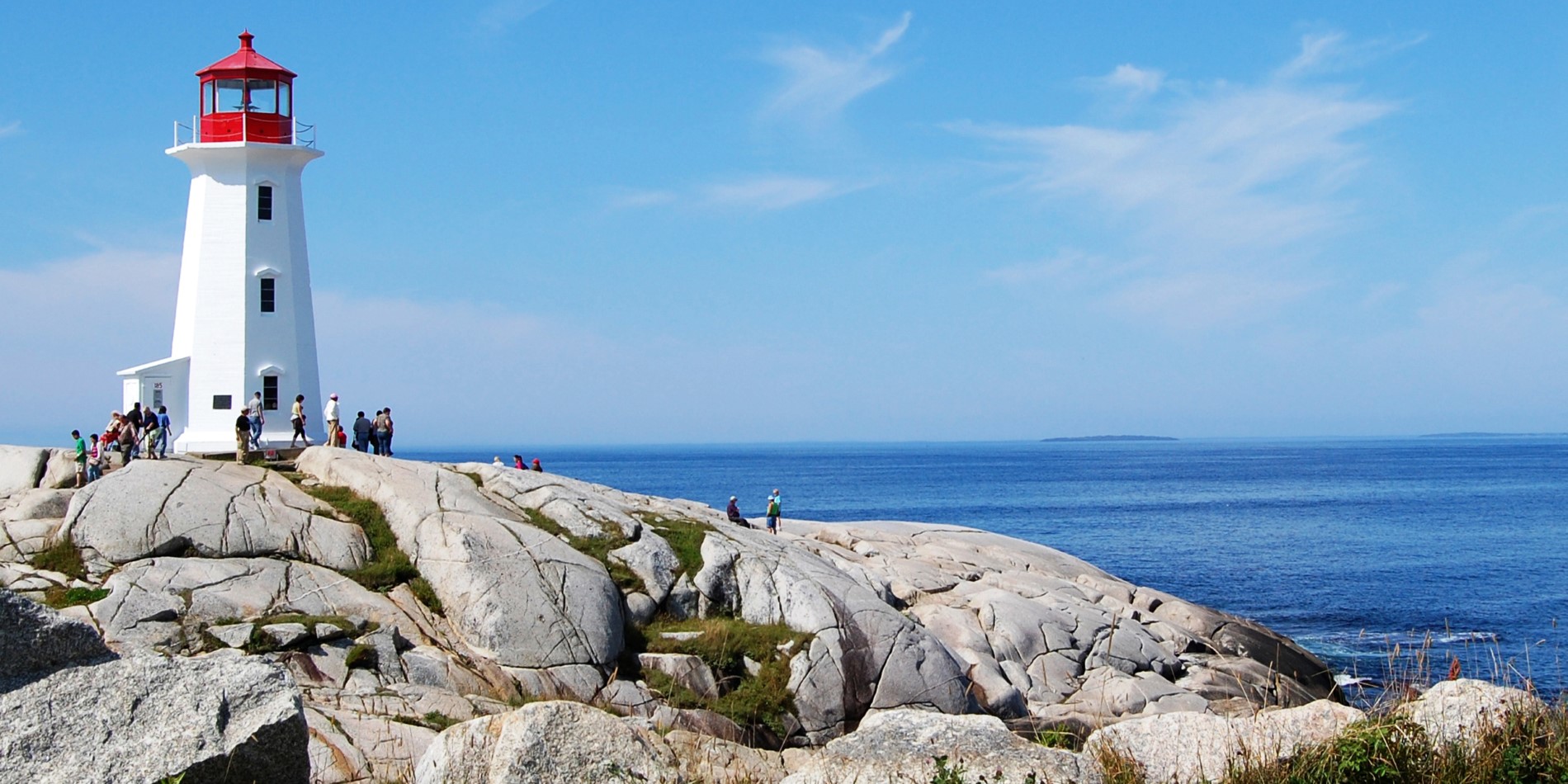 En staty av en person som sitter på en klippa nära havet
