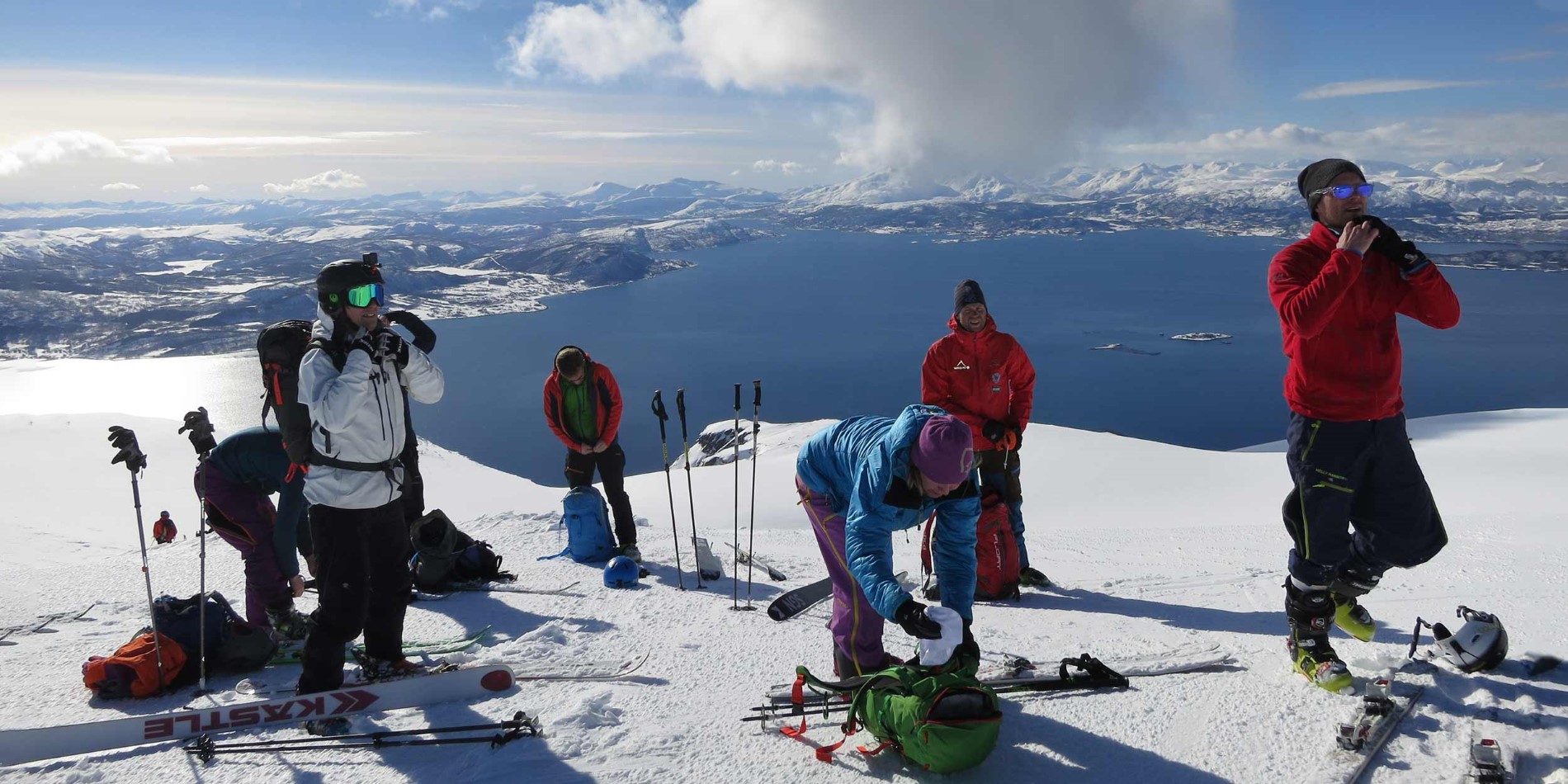 En grupp människor åker skidor ovanpå ett snötäckt berg